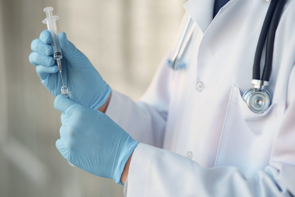 Reconstruct Face - A doctor in a white coat showcasing surgical techniques with a syringe.