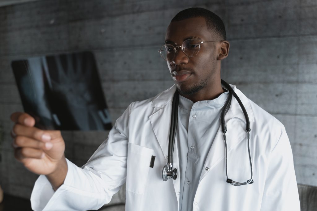 Reconstruct Face - A black male doctor evaluating an x-ray for facial reconstruction surgery.