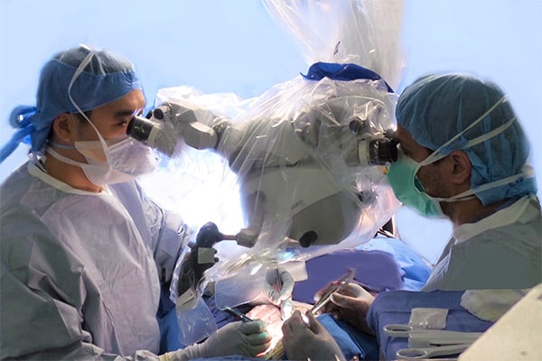 Reconstruct Face - Two surgeons performing facial reconstruction surgery in an operating room.